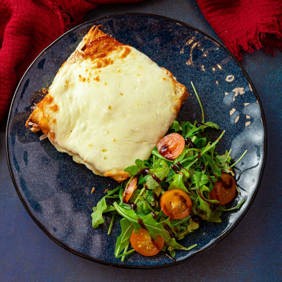 Vita Nostra's Argentinian milanesa napolitana, topped with melted cheese, served with a side salad.
